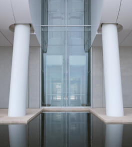 Mareterra, Renzo Piano Building Workshop, Monaco, 2024 — symmetrical columns flanking glazed lift shaft with reflecting pool 