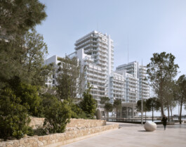 Mareterra, Renzo Piano Building Workshop, Monaco, 2024 — residential towers seen from landscaped promenade with stone wall and pine trees 